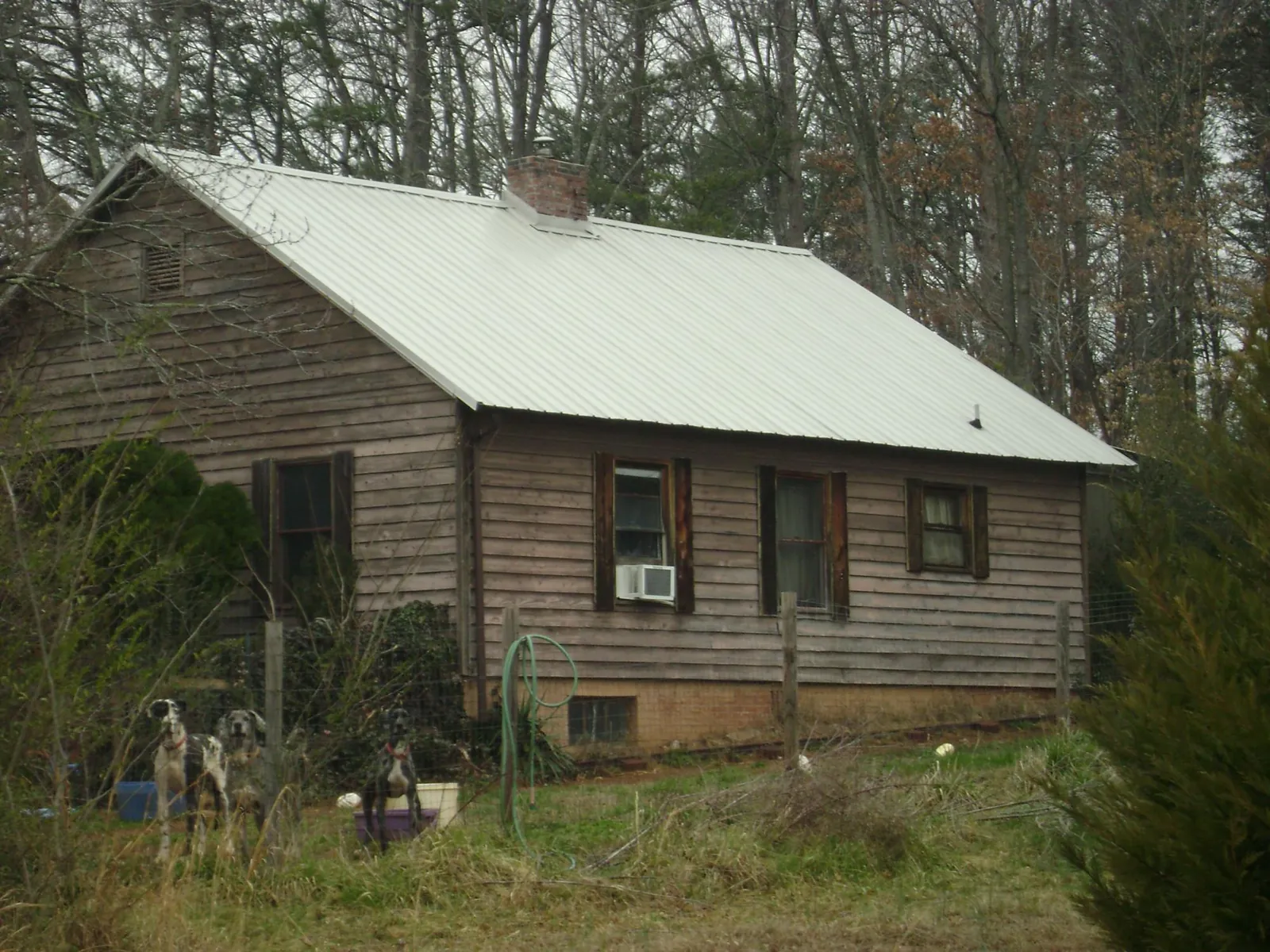 White metal roof on an old wood sided farmhouse, from a Metal Roof Installation job in Johnstown